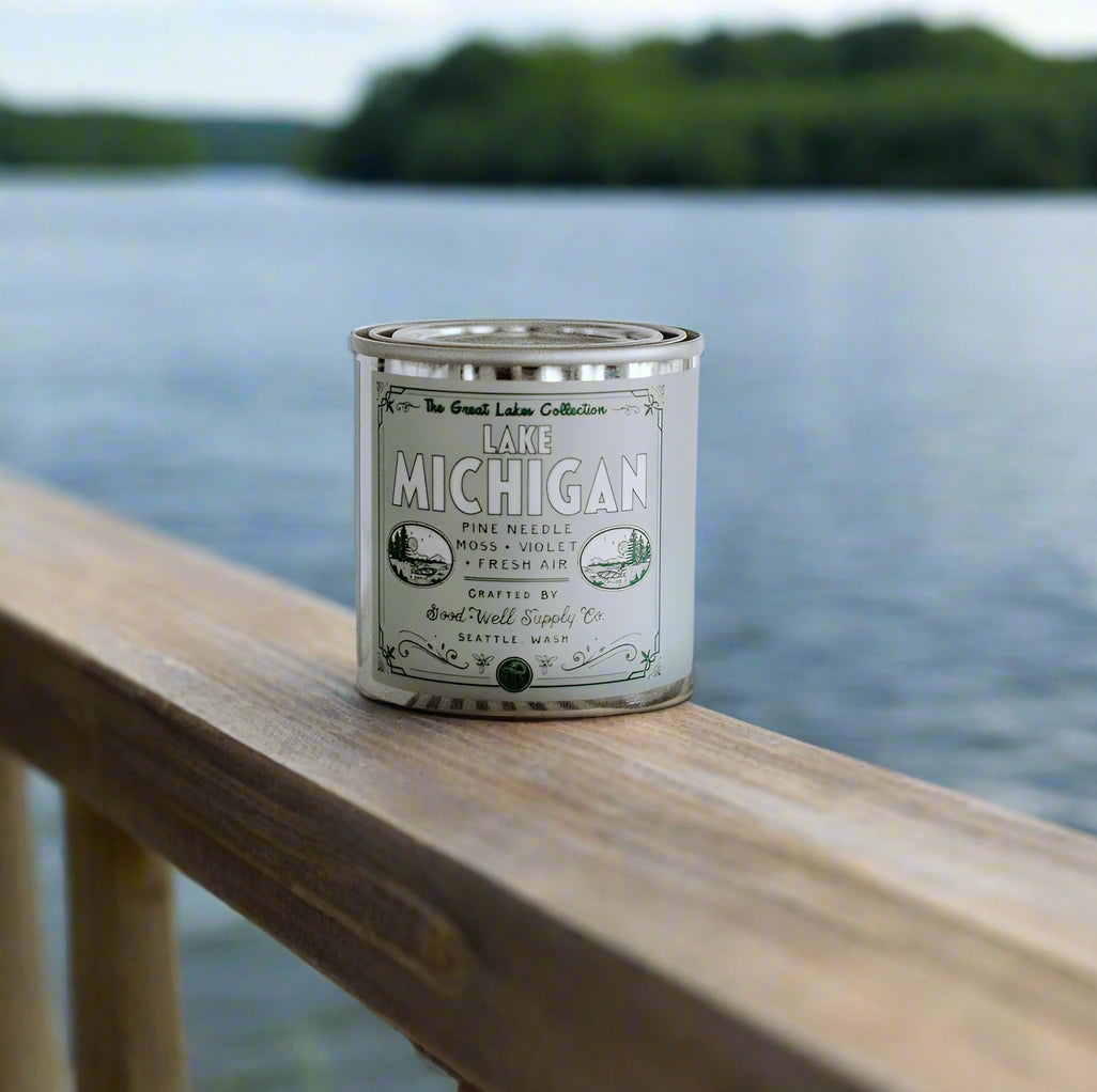 Candle canister labeled 'Lake Michigan' on a striped fabric background